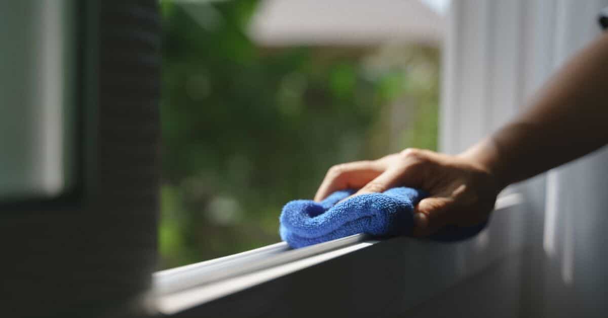 cleaning window sill with rag